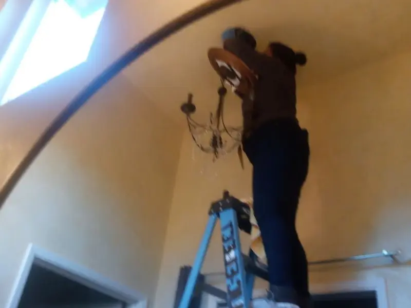 Electrician installing a chandelier in a Cockeysville residence